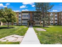 Attractive multi-story apartment building with manicured lawns and mature trees at 9150 E Center Ave # 7C, Denver, CO 80247