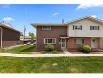 A brick home with a well-manicured lawn offers curb appeal and a welcoming exterior on a sunny day at 9044 E Nassau Ave, Denver, CO 80237