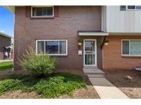 Charming brick home with a well-maintained front yard and a welcoming entrance adorned with hanging flower baskets at 9044 E Nassau Ave, Denver, CO 80237