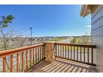 Scenic balcony showcasing neighborhood and blue skies views through wood and stone railing at 7511 S Sicily Way, Aurora, CO 80016