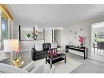 Bright living room with gray floors, modern decor, and comfortable seating arrangement at 807 Mobile St, Aurora, CO 80011