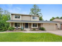 Inviting two-story home featuring a well-manicured lawn and a charming brick facade at 8433 S Painted Sky St, Highlands Ranch, CO 80126