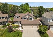 Charming two-story home with a three-car garage, manicured landscaping, and mature trees at 2146 S Ellis Ct, Lakewood, CO 80228
