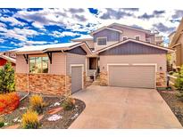 Charming two-story home with an attached two car garage and appealing stone accents at 17630 W 94Th Dr, Arvada, CO 80007