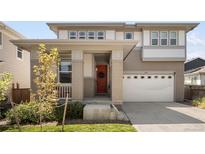 Charming two-story home featuring an orange front door and a well-manicured lawn at 6099 N Netherland Ct, Aurora, CO 80019
