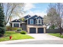 Inviting two-story home with a two-car garage, landscaped yard, and classic architectural details at 18 Brixham Ct, Castle Pines, CO 80108