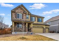 Stunning two-story home featuring a stone facade, well-manicured lawn, and a three-car garage in a desirable neighborhood at 21096 E Bellewood Dr, Centennial, CO 80015