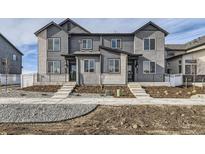Modern townhouse exterior with gray siding, brick accents, and inviting entryway steps at 1288 S Algonquian St, Aurora, CO 80018