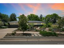Charming home with lush front yard landscaping, a lovely walkway, and beautiful trees at 3519 S Holly St, Denver, CO 80237