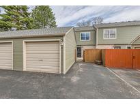 View of the townhome featuring attached garage and partially fenced front patio at 3415 S Ammons St # 24-2, Lakewood, CO 80227