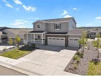 Two-story home with a welcoming porch, a spacious driveway, and a manicured front yard at 5166 Trails Edge Ln, Castle Rock, CO 80104