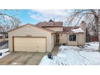 Charming home featuring a well-maintained front yard, attached garage, and cozy entranceway at 9600 W Wagon Trail Dr, Littleton, CO 80123