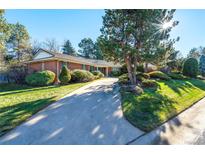 Inviting brick home features a well-manicured lawn and a lengthy driveway leading up to the residence at 4000 S Clermont St, Cherry Hills Village, CO 80113