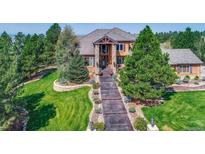 Beautiful two-story home showcasing a sprawling manicured lawn and a lengthy walkway to the front door at 5449 Songbird Way, Parker, CO 80134