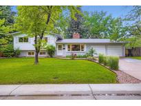 Charming home with a well-maintained lawn, mature trees, and a brick facade at 1715 Alkire St, Golden, CO 80401