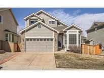Attractive home exterior with a well-maintained lawn, stone accents, and an attached two-car garage at 16564 High Desert Way, Parker, CO 80134