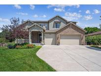 Charming two-story home with brick accents, a well-manicured lawn, and a two-car garage at 3890 Tabor Ct, Wheat Ridge, CO 80033