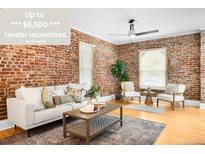 Inviting living room featuring exposed brick walls, hardwood floors, and comfortable seating at 3375 W 37Th Ave, Denver, CO 80211
