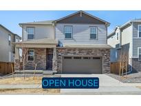 Charming two-story home featuring a stone facade and an attached two-car garage at 6083 Sugarloaf St, Brighton, CO 80601