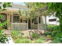 Charming front exterior featuring a cozy porch, mature trees, and professionally landscaped yard at 3319 Newton St, Denver, CO 80211