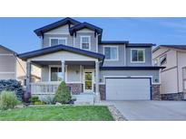 Charming two-story home with a covered front porch and well-maintained landscaping at 8489 S Quay St, Littleton, CO 80128