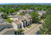 This aerial view captures a multi-Gathering residence with light gray exterior paint in a lush, green neighborhood at 6011 Yarrow St # I, Arvada, CO 80004