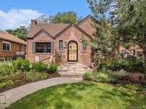 Charming brick home featuring a landscaped front yard and inviting entrance at 1423 Dahlia St, Denver, CO 80220