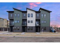 Modern townhome exterior featuring a stylish design with a combination of neutral colors and a well-manicured front yard at 8400 W 52Nd Ave, Arvada, CO 80002
