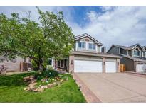Charming two-story home featuring a well-manicured lawn and three-car garage, and delightful curb appeal at 7176 S Pierson St, Littleton, CO 80127