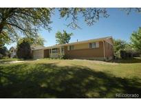 Ranch-style home with brick facade and a spacious yard at 12058 E Virginia Pl, Aurora, CO 80012