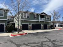 Two-story exterior of a home featuring a three-car garage, green siding, and stone accents at 17326 Waterhouse Cir # B, Parker, CO 80134