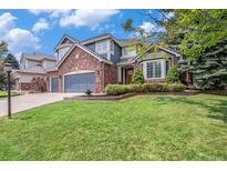 Charming two-story home with a well-maintained lawn, brick accents, and a three car garage at 21416 E Ottawa Cir, Aurora, CO 80016