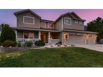 Charming two-story home with a well-manicured lawn, inviting porch, and attached two-car garage at 1805 Parkdale N Cir, Erie, CO 80516