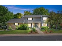 Charming two-story home featuring a well-manicured lawn, mature trees, and a welcoming facade with brick and neutral siding at 3726 E Nichols Ave, Centennial, CO 80122