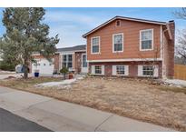 Charming exterior showcasing a well-maintained front yard and classic brick accents on a split-level home at 1301 S Yampa Ct, Aurora, CO 80017