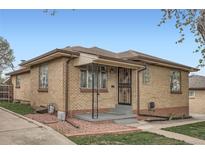 Charming single-story brick home with an inviting entryway and well-maintained landscaping on a sunny day at 4840 Depew St, Denver, CO 80212