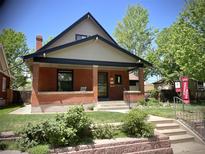 Charming brick home with a covered front porch and well-manicured lawn at 1731 S Ogden St, Denver, CO 80210