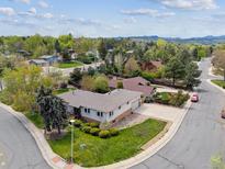 Inviting single-Gathering home with lush lawn and mature landscaping, offering a serene suburban setting at 3229 Swadley St, Wheat Ridge, CO 80033