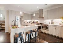 Modern kitchen featuring stainless steel appliances, light wood cabinetry, and a spacious island with seating at 1333 Elati St # 3, Denver, CO 80204