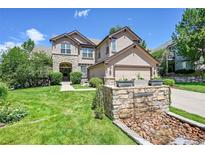 Inviting home exterior with stone accents, lush lawn, and charming water feature at 3311 Klondike Pl, Castle Rock, CO 80108