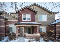 Brick townhouse exterior with a covered entryway and landscaping at 6436 Silver Mesa Dr # E, Highlands Ranch, CO 80130