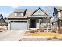 Charming two-story home boasts a well-maintained lawn, covered porch, and attached two-car garage at 8503 Estes Park Ave, Littleton, CO 80125