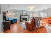 Cozy living room with hardwood floors, fireplace, and comfortable seating, offering a relaxing atmosphere at 8001 W 57Th Ave, Arvada, CO 80002
