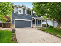Charming two-story home featuring a well-manicured lawn, inviting front porch, and an attached two-car garage at 1672 Maccullen Dr, Erie, CO 80516