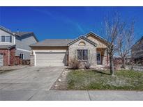 Brick ranch home with attached garage and landscaped yard at 15119 E 119Th Ave, Commerce City, CO 80603