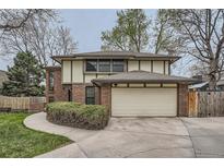 Two-story brick and stucco home featuring an attached two-car garage and mature landscaping at 3633 S Ingalls St, Denver, CO 80235