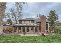 Charming home boasts a brick sunroom, spacious backyard, and inviting patio area for outdoor entertaining at 3633 S Ingalls St, Denver, CO 80235