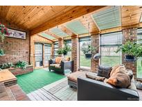 Cozy sunroom with brick walls, wood ceiling, and ample seating at 3633 S Ingalls St, Denver, CO 80235