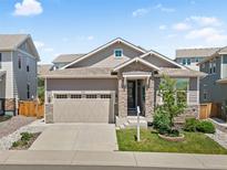 Charming single Gathering home featuring stone accents, a two-car garage, and manicured front lawn at 4089 Forever Cir, Castle Rock, CO 80109