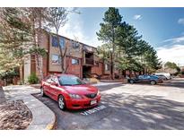 Brick and wood condo building with visitor parking and mature landscaping for a welcoming curb appeal at 420 Wright St # 101, Lakewood, CO 80228